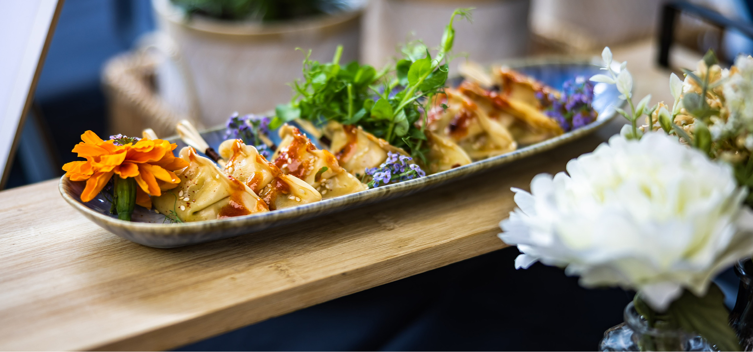 Asiatische Gyoza-Fingerfood auf einem Catering-Buffet mit Sesam und Sauce angerichtet